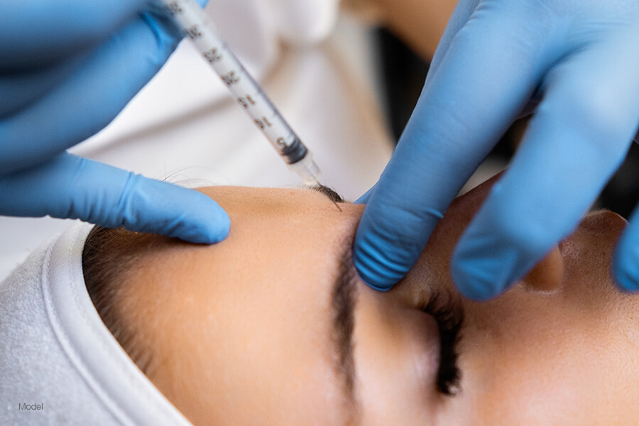 Woman receiving Botox injection in her forehead